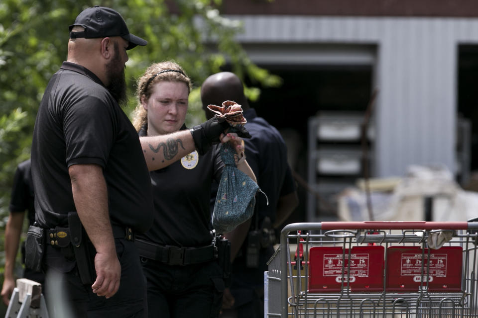 An San Antonio Animal Care Services officer hands a bag containing a snake removed from a home in the 500 block of Kayton Avenua on San Antonio's Southside to a fellow officer Wednesday, Sept. 5, 2018. Over 100 snakes, including two 12-15 foot long reticulated pythons were discovered at the home. (Josie Norris /The San Antonio Express-News via AP)