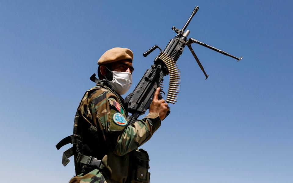 An Afghan National Army soldier holds a machine gun at a checkpoint on the outskirts of Kabul  - Mohammad Ismail/Reuters