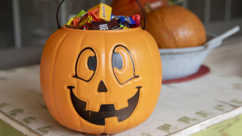 Plastic pumpkin pail filled with candy