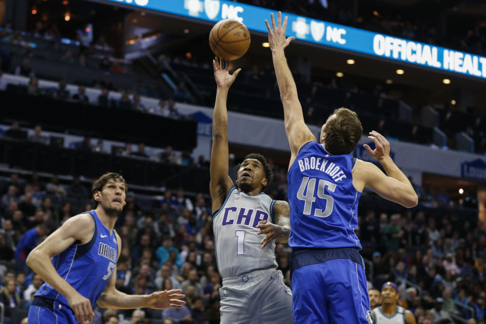 Charlotte Hornets guard Malik Monk, center, shoots against Dallas Mavericks guard Ryan Broekhoff as Dallas Mavericks center Boban Marjanovic looks on in the first half of an NBA basketball game in Charlotte, N.C., Saturday, Feb. 8, 2020. (AP Photo/Nell Redmond)