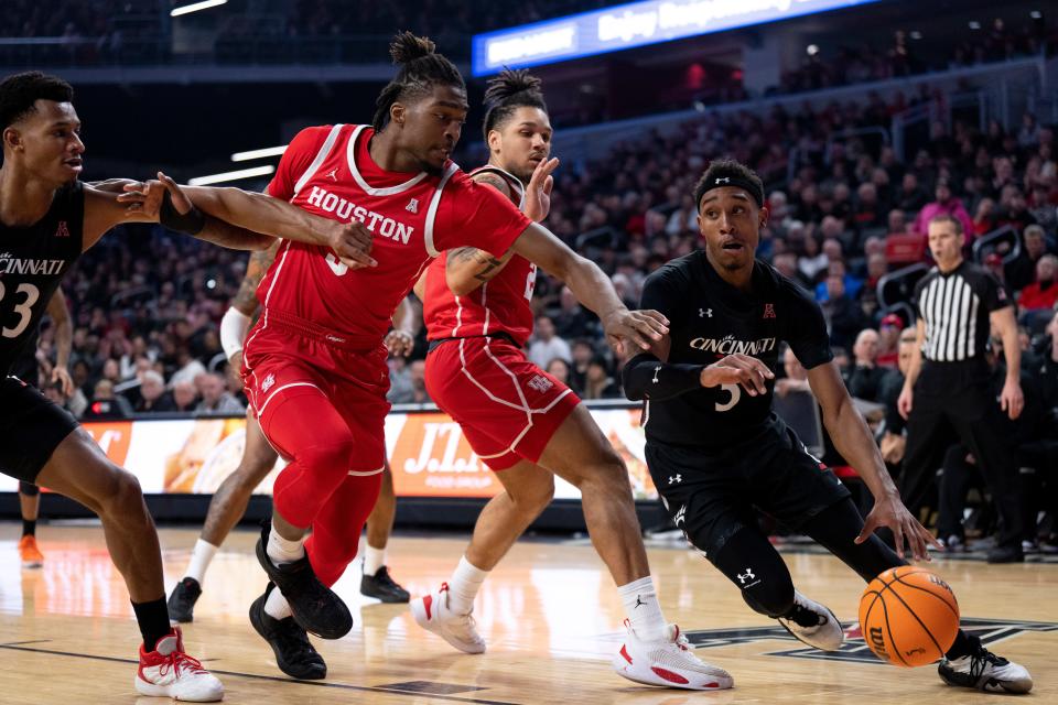 Cincinnati Bearcats guard Mika Adams-Woods (3) dribbles around Houston Cougars forward Ja'Vier Francis (5) in their game at Fifth Third Arena Sunday. Adams-Woods led the Bearcats with 19 points.