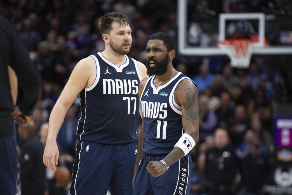 Dallas Mavericks guard Luka Doncic (77) and guard Kyrie Irving (11) react as the Sacramento Kings call for a timeout late in the second half of an NBA basketball game in Sacramento, Calif., Friday, March 29, 2024. (AP Photo/José Luis Villegas)