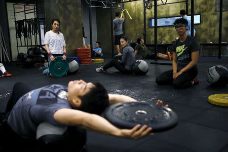 You Ri-seul (L), 29, and Kim Jin-ah (C), 31, take part in a crossfit class at a gym in Seoul, September 11, 2015. REUTERS/Kim Hong-Ji