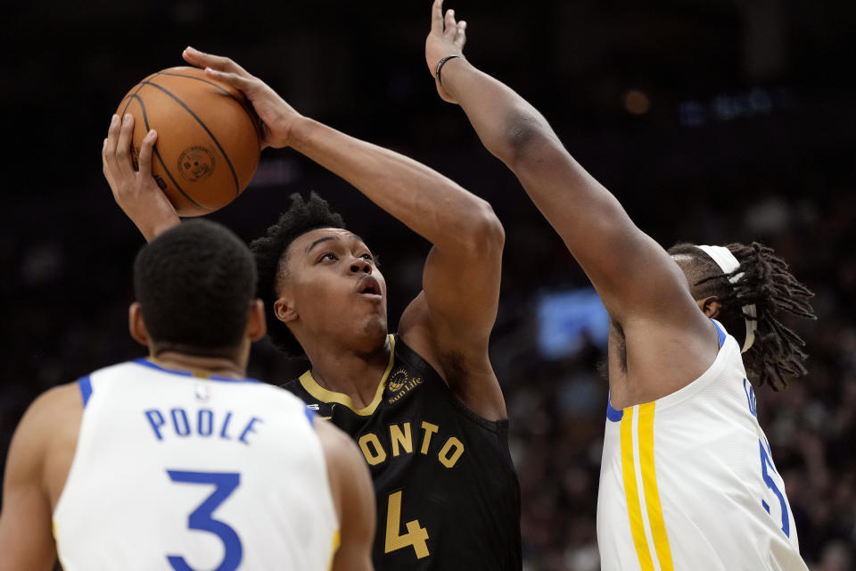 Toronto Raptors forward Scottie Barnes (4) looks to shoot while under pressure from Golden State Warriors center Kevon Looney (5) and Jordan Poole (3) during first-half NBA basketball game action in Toronto, Sunday, Dec. 18, 2022. (Frank Gunn/The Canadian Press via AP)