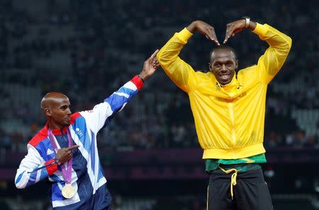 Jamaica's Usain Bolt (R) celebrates with Britain's Mo Farah on the podium after each receiving gold medals, Bolt for men's 4x100m relay and Farah for men's 5000m, at the victory ceremony at the London 2012 Olympic Games at the Olympic Stadium in Britain August 11, 2012. REUTERS/Eddie Keogh