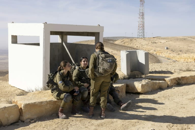 Des femmes soldats israéliennes de l'unité d'infanterie mixte du bataillon Bardelas, s'assoient après un exercice d'entraînement à l'est de la ville de Mitzpe Ramon, dans le sud d'Israël, le 18 janvier 2024 (MENAHEM KAHANA)