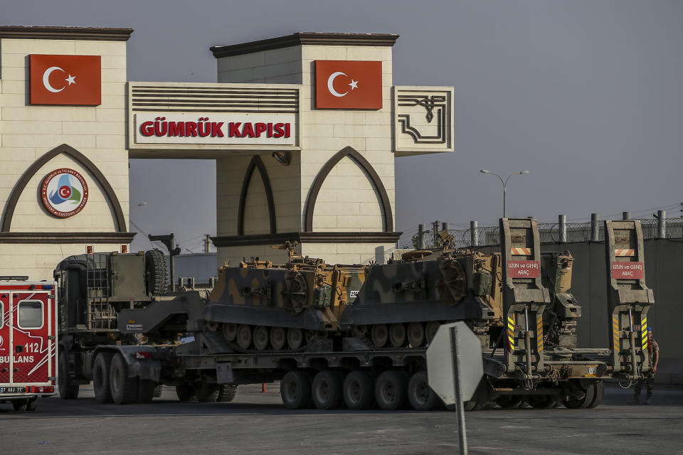 A Turkish forces truck transporting armoured personnel carriers, crosses the border with Syria in Karkamis, Gaziantep province, southeastern Turkey, Tuesday, Oct. 15, 2019. Turkey defied growing condemnation from its NATO allies to press ahead with its invasion of northern Syria on Tuesday, shelling suspected Kurdish positions near the border amid reports that Syrian Kurds had retaken a key town. (AP Photo/Emrah Gurel)