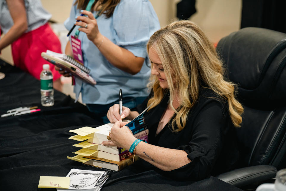 Hoover signs as many books and miscellaneous items as people bring to her.<span class="copyright">Courtesy of Lauren Black/Book Bonanza</span>