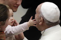 <p>Papst Franziskus wird bei seiner wöchentlichen Audienz im Vatikan von einen Kleinkind im Gesicht berührt. (Bild: AP Photo/Borgia) </p>