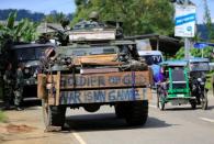 A tricycle cab drives past an armoured personnel carrier parked along a main road in Pantar village, Lanao Del Norte, Philippines June 21, 2017. REUTERS/Romeo Ranoco