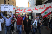 Anti-government protesters shout slogans during a protest to denouncing the naming of former Prime Minister Saad Hariri as a potential candidate as the country's new prime minister, in downtown Beirut, Lebanon, Wednesday, Oct. 21, 2020. Hariri resigned a year ago amid nationwide protests against government corruption and mismanagement of Lebanon's resources. The Arabic placard reads:"Saad don't dream on it any more." (AP Photo/Hussein Malla)