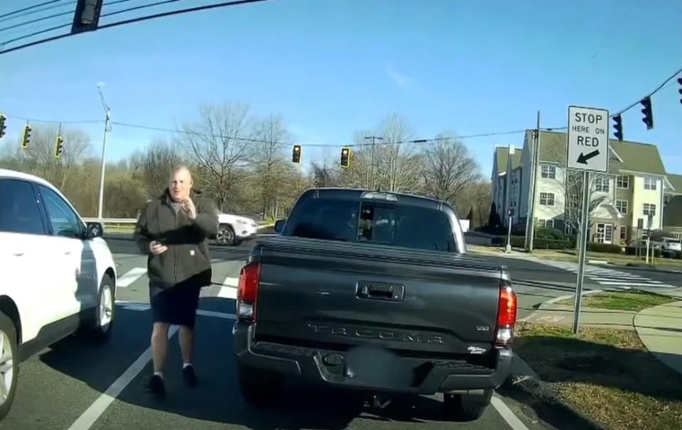 Meriden Police Department off-duty cop Allen Ganter is seen exiting his truck and waving his badge after being honked at for not turning right on red. YouTube/NBC Connecticut