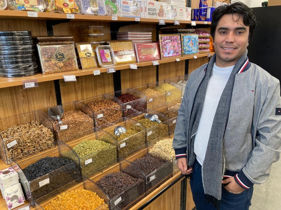 Wazir Hashimi, owner of Ariana Natural Market in Essex Junction, stands Nov. 27, 2023 near a display of nuts from Afghanistan and dried fruit.