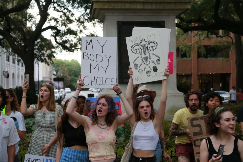 Abortion-rights supporters hold signs and chant during a rally Tuesday evening in Johnson Square.