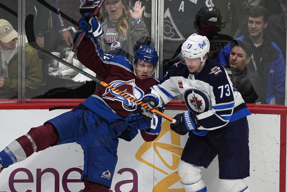 Winnipeg Jets center Tyler Toffoli, right, checks Colorado Avalanche defenseman Josh Manson during the third period of Game 3 of an NHL hockey Stanley Cup first-round playoff series Friday, April 26, 2024, in Denver. (AP Photo/David Zalubowski)