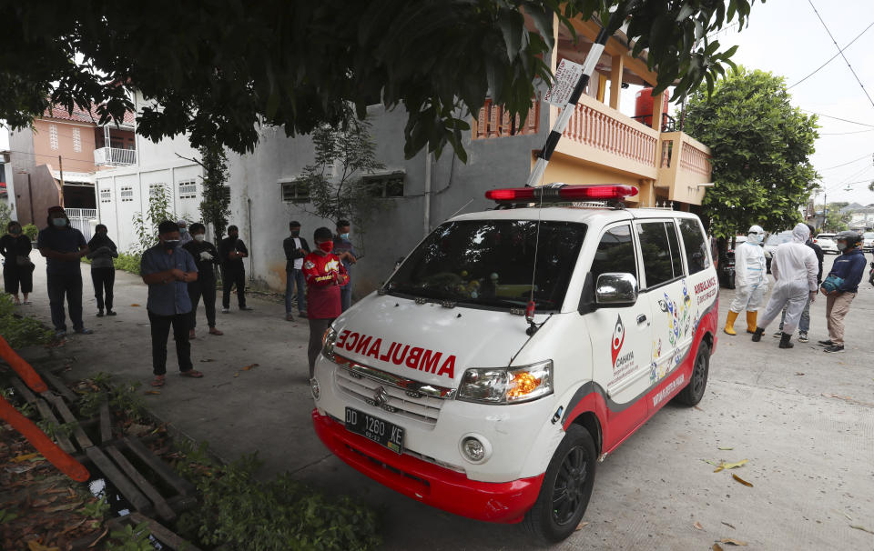 Relatives pray as an ambulance carries away the body of COVID-19 victim in Bekasi on the outskirts of Jakarta, Indonesia, July 11, 2021. Indonesia surpassed the grim milestone of 100,000 official COVID-19 deaths on Wednesday, Aug. 4, 2021, as the country struggles with its worst pandemic year fueled by the delta variant, with growing concerns that the actual figure could be much higher with people also dying at home. (AP Photo/Achmad Ibrahim)