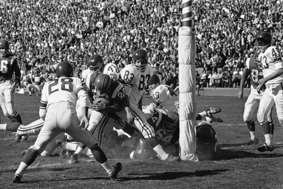 Jim Brown (32, with ball) of the Cleveland Browns and a member of the East All-Stars plunges over from the one-yard line in the first period of Pro Bowl game, Jan. 13, 1963, Los Angeles, Calif. Others in the picture include Yale Lary (28), Gino Marchetti (83), Matt Hazeltine (48) and Bill Forester (71) of the West All-Stars; Jim Ray Smith (64) of the East.