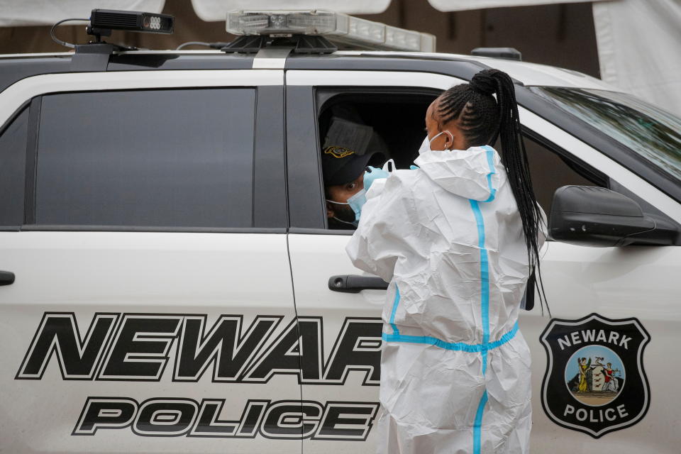 A healthcare worker takes a swab from a Newark Police officer sitting in a car at a drive-thru COVID-19 test center, during a surge in the coronavirus disease (COVID-19) infections in Newark, New Jersey, U.S., November 12, 2020. REUTERS/Brendan McDermid TPX IMAGES OF THE DAY