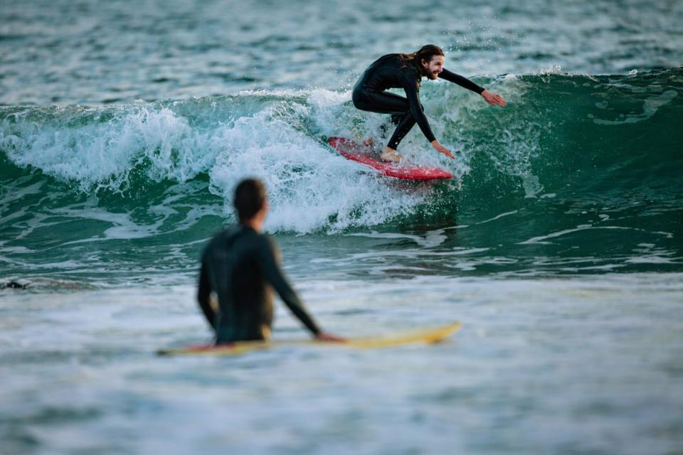 A surfer catches a wave at Venice Beach on Thursday.