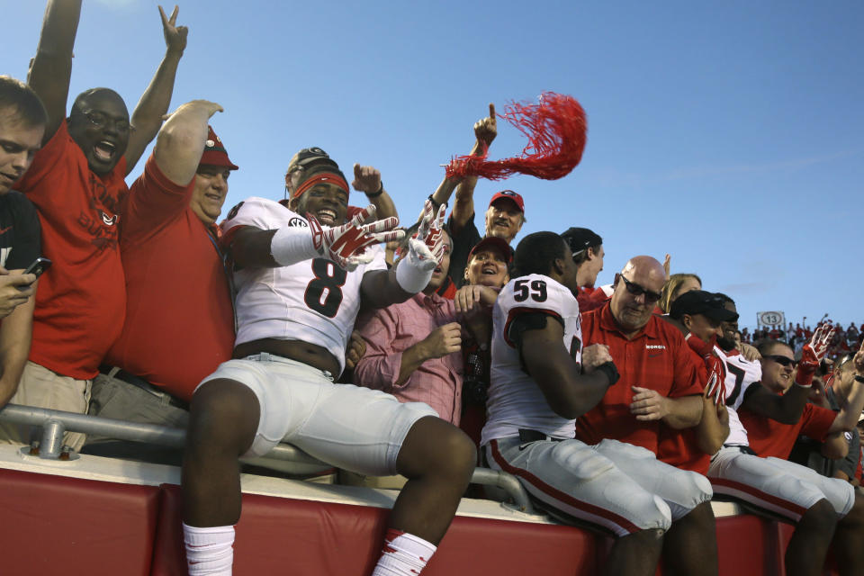 Georgia linebacker Shaun McGee (8) celebrates with fans after an NCAA college football game in Little Rock, Ark., Saturday, Oct. 18, 2014. Georgia defeated Arkansas 45-32. (AP Photo/Danny Johnston)