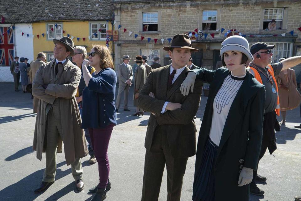 allen leech and michelle dockery dressed in 1920s attire on a concrete movie set of the new downton abbey movie