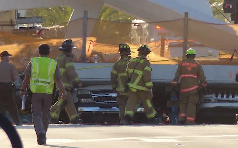 Miami Dade fire rescue personnel work the scene of a pedestrian bridge collapse in Miami - Credit: GASTON DE CARDENAS /AFP