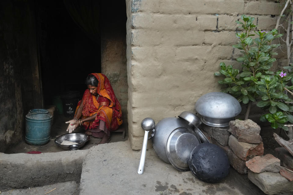 A woman living in a slum makes dough out of wheat flour in her hut on the outskirts of Patna, in the Indian state of Bihar, on May 11, 2024. (AP Photo/Manish Swarup)