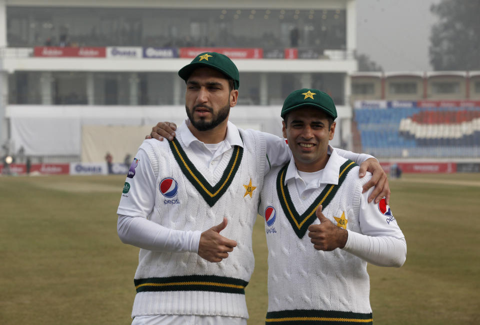 Pakistan's Usman Shinwari, left, and Abid Ali who are playing their first test, pose for photograph before start the game of first day of the first cricket test match between Pakistan and Sri Lanka, in Rawalpindi, Pakistan, Wednesday, Dec. 11, 2019. (AP Photo/Anjum Naveed)