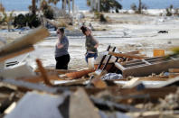 Christina Amanda, right, and Connie Huff, wait for an insurance adjuster as they look for their possessions at the site of their destroyed home in the aftermath of Hurricane Michael in Mexico Beach, Fla., Wednesday, Oct. 17, 2018. (AP Photo/Gerald Herbert)