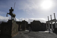 A journalist takes pictures in the archeological site of Pompeii during the inauguration of the museum Antiquarium, in Pompeii, southern Italy, Monday, Jan. 25, 2021. Decades after suffering bombing and earthquake damage, Pompeii's museum is back in business, showing off exquisite finds from excavations of the ancient Roman city. Officials of the archaeological park of the ruins of the city destroyed in 79 A.D. by the eruption of Mount Vesuvius inaugurated the museum on Monday. (AP Photo/Gregorio Borgia)