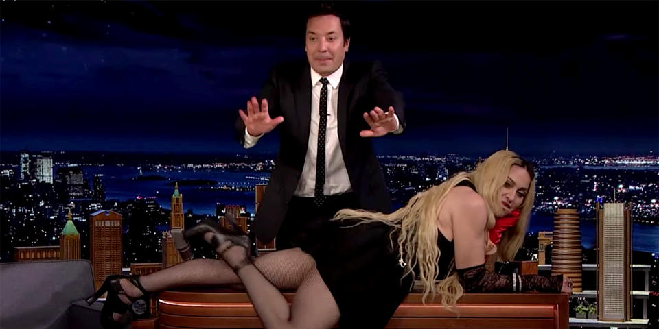 Pop star Madonna drapes herself across TV host Jimmy Fallon's desk in an episode that aired on Oct. 7, 2021. (YouTube)