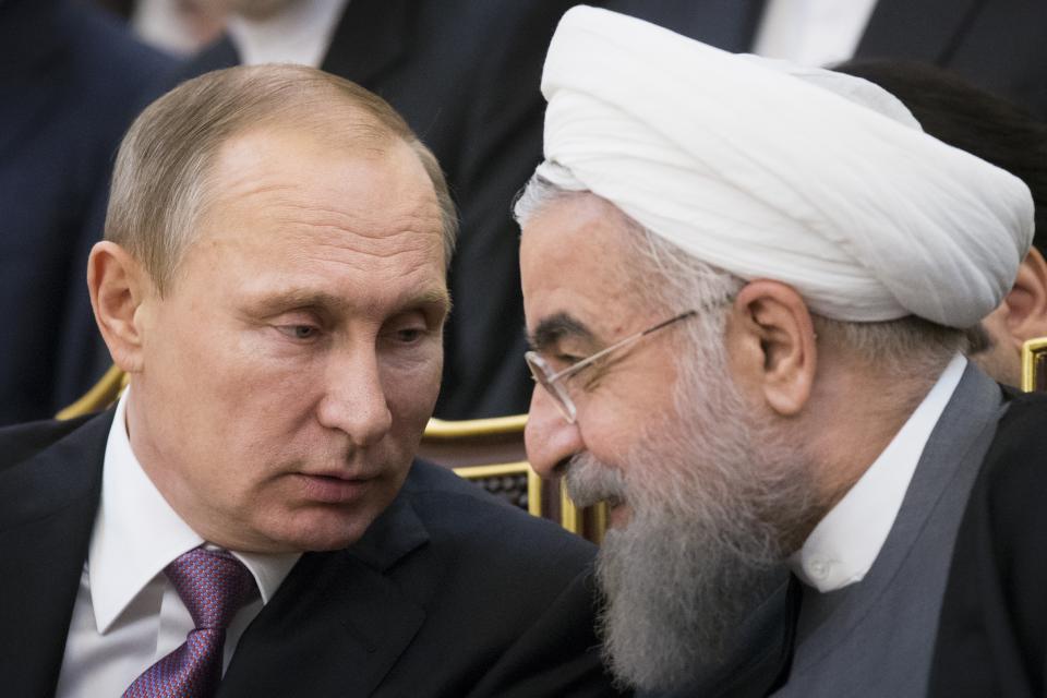 FILE - Russian President Vladimir Putin, left, and Iran's President Hassan Rouhani talk to each other as they attend a signing ceremony during the Gas Exporting Countries Forum (GECF) in Tehran, Iran, on Nov. 23, 2015. Russia and Iran have grown increasingly close in recent years, and Tehran has supplied Moscow with drones amid the fighting in Ukraine. (AP Photo/Alexander Zemlianichenko, File)