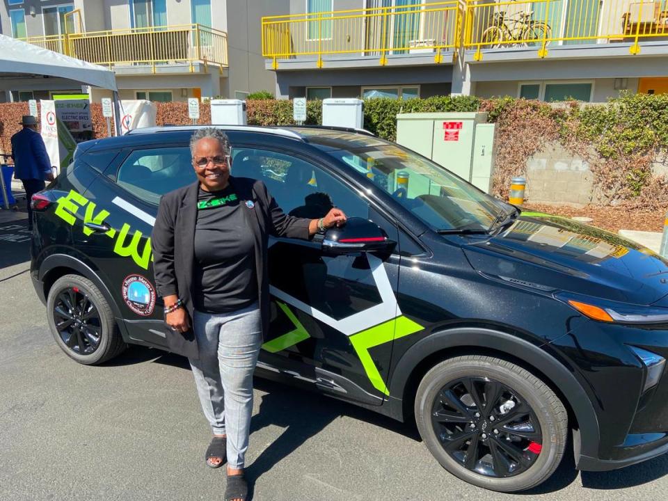 Cassandra Little, president/CEO of the Fresno Black Metro Chamber of Commerce, poses with a branded electric car that is part of the Clean Shared Mobility Network. All but two of the network’s 40 EV cars are unmarked.