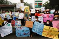 Youths gather with placards during a Global Climate Strike rally as smog covers the city due to the forest fires in Palangka Raya