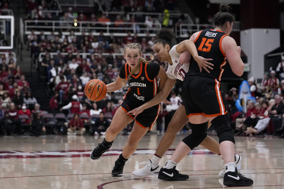 Oregon State guard Kennedie Shuler, left, moves the ball while defended by Stanford forward Courtney Ogden, center, during the first half of an NCAA college basketball game, Sunday, Jan. 21, 2024, in Stanford, Calif. (AP Photo/Godofredo A. Vásquez)