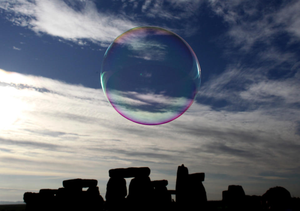 AMESBURY, ENGLAND - JUNE 21:  A bubble floats past as revelers watch as the midsummer sun rises just after dawn over the megalithic monument of Stonehenge on June 21, 2010 on Salisbury Plain, England. (Photo by Matt Cardy/Getty Images)