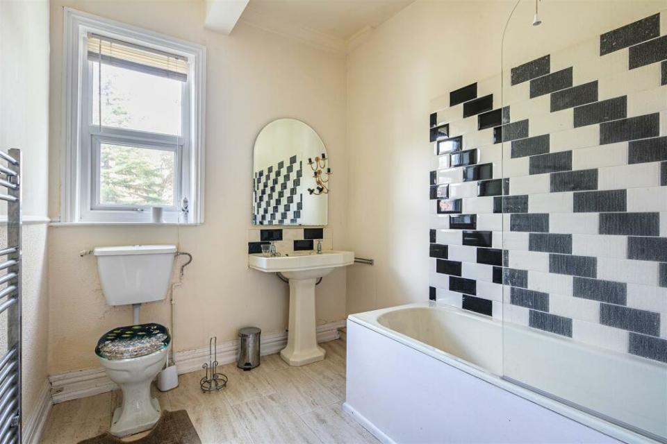 The first floor bathroom has a monochrome theme, and a shower bath.