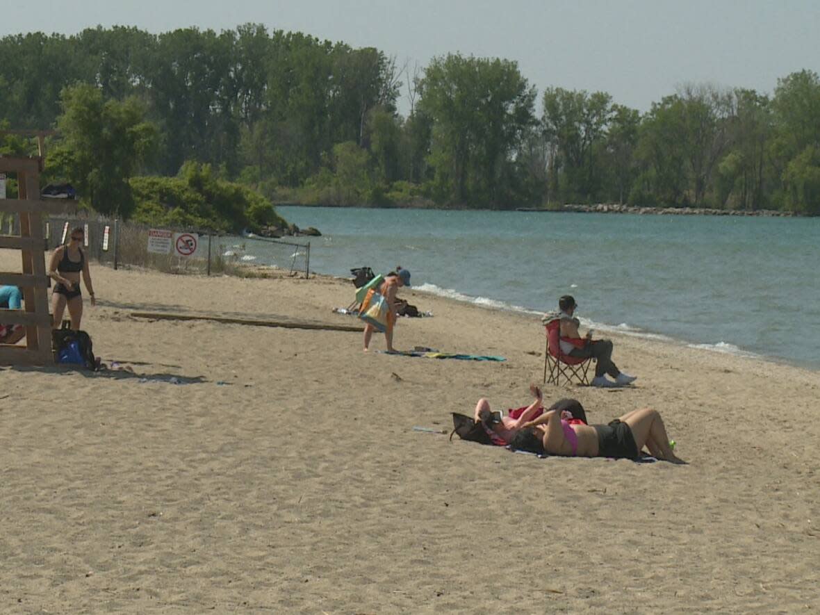 Beachgoers set up and relax at Sandpoint Beach in Windsor. The city says it officially opens with staffed lifeguards June 10, weather and water quality permitting. (Jacob Barker/CBC - image credit)