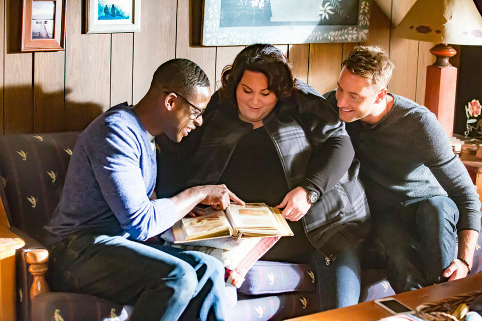 three of the characters sitting on a couch looking at a photo album