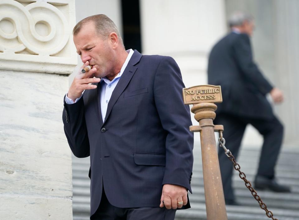 Rep. Troy Nehls, R-Texas, smokes a cigar after the House approved a bill Wednesday, March 13, 2024, that would force TikTok's parent company to sell the popular social media app or face a ban practice in the United States.