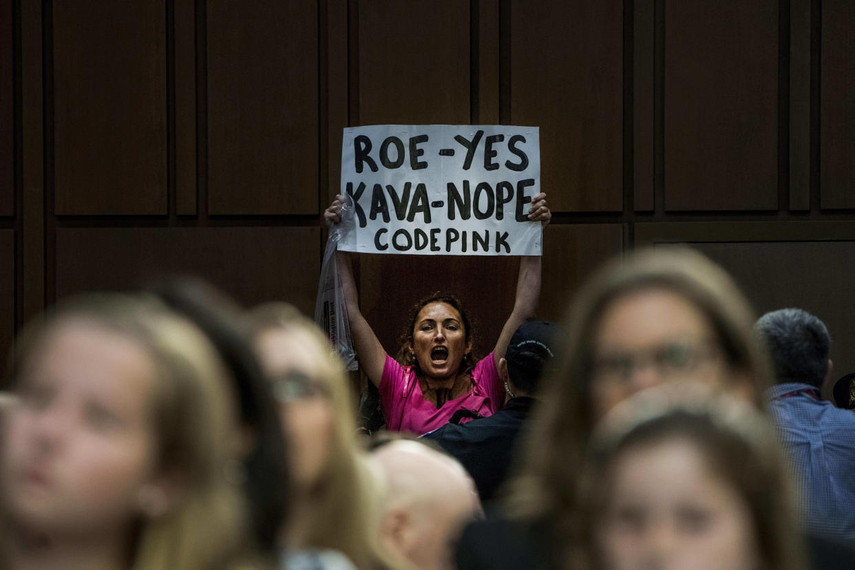 A woman holds up a sign in protest on Tuesday during the Senate confirmation hearing for Brett Kavanaugh. (Photo: The Washington Post via Getty Images)