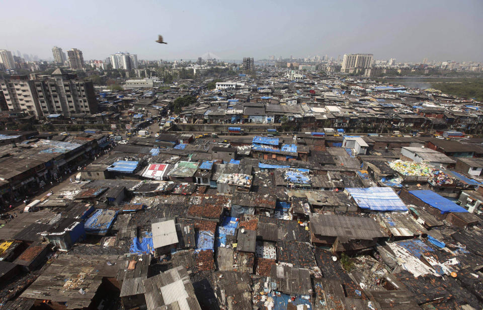 FILE - In this Oct. 27, 2010 file photo, a bird flies over Dharavi, one of Asia's largest slum, in Mumbai, India. Dharavi has had more than 1,800 confirmed COVID-19 cases, and is among Mumbai’s most affected pockets. The caseload in the city known for Bollywood and the country’s most important stock exchange stood at more than 41,000 on Thursday, and has overwhelmed the under-funded health system. (AP Photo/Rafiq Maqbool, File)