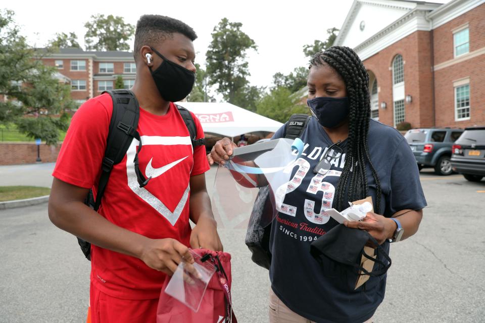 Sophomore Brandon Williams of the Bronx and his mother, Julie Andrew, look at a welcome bag which included a face mask, hand sanitizer and a face shield at Iona College in New Rochelle, N.Y., on Aug. 13.