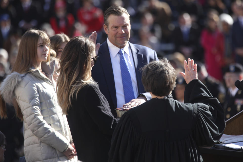 FILE - Republican Kris Kobach takes the oath of office as Kansas attorney general as his family watches during a ceremony on the south steps of the Statehouse, Monday, Jan. 9, 2023, in Topeka, Kan. Kobach is asking the Kansas Supreme Court to reconsider a 2019 ruling that access to abortion is a "fundamental" right under the state constitution. (AP Photo/John Hanna, File)