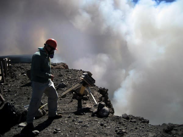 A geologist from the Hawaii Volcano Observatory checks on a time-lapse camera positioned at the rim of Halema'uma'u crater, at Kilauea's summit.