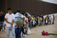 Migrants who had crossed the Rio Grande river into the U.S. wait to be processed by U.S. Border Patrol agents in Eagle Pass, Texas, Friday, May 20, 2022. The Eagle Pass area has become increasingly a popular crossing corridor for migrants, especially those from outside Mexico and Central America, under Title 42 authority, which expels migrants without a chance to seek asylum on grounds of preventing the spread of COVID-19. A judge was expected to rule on a bid by Louisiana and 23 other states to keep Title 42 in effect before the Biden administration was to end it Monday. (AP Photo/Dario Lopez-Mills)