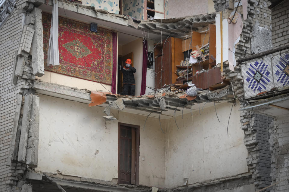 A Ukrainian Emergency Service rescuer inspects a building damaged by Russian shelling in Mykolayiv, Ukraine, Saturday, Nov. 12, 2022. (AP Photo/Efrem Lukatsky)