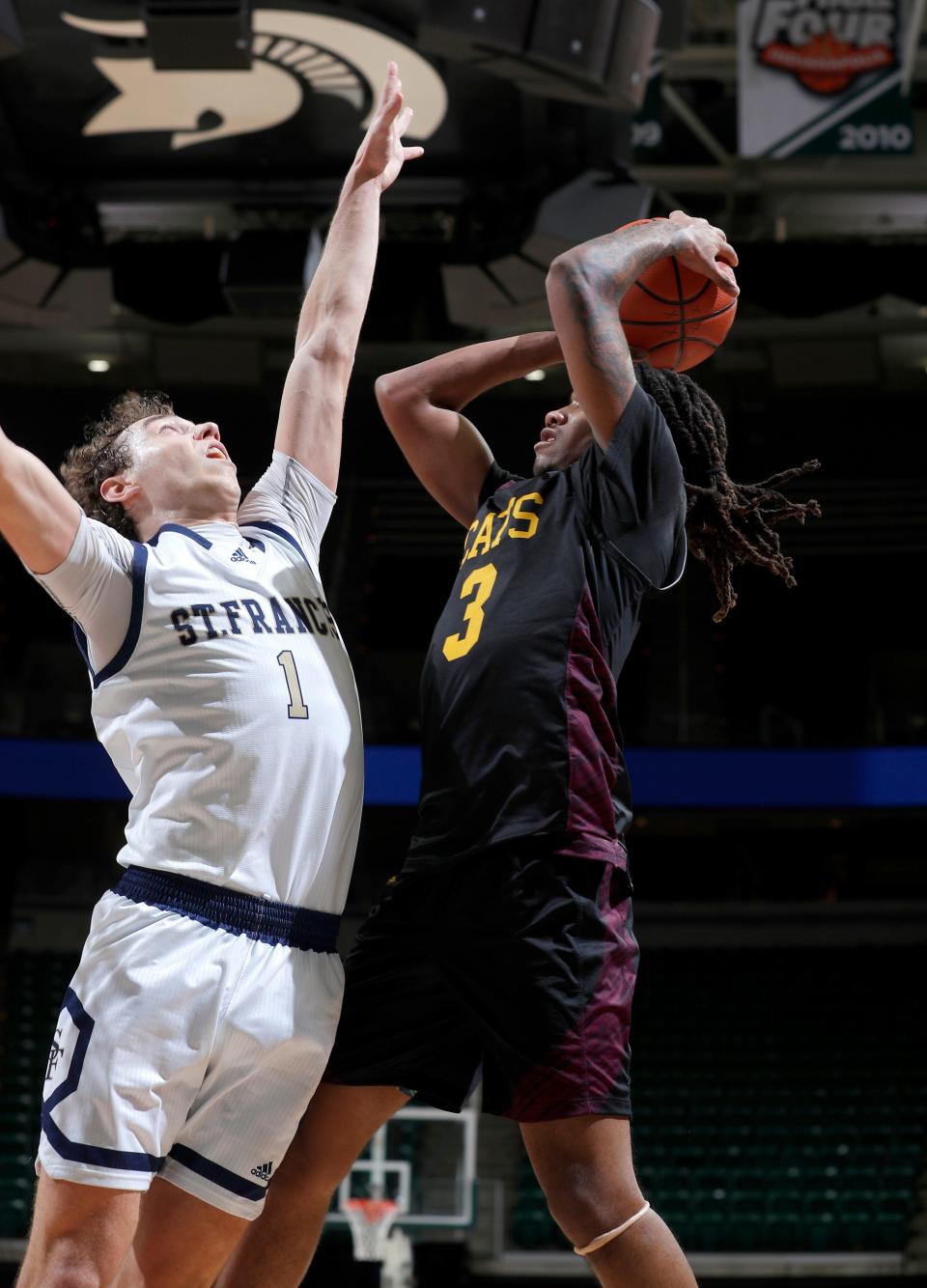 Niles Brandywine's Jaremiah Palmer, right, shoots against Traverse City St. Francis' Wyatt Nausadis in their MHSAA semifinal game, Thursday, March 23, 2023, in East Lansing.