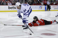 Toronto Maple Leafs center Auston Matthews (34) controls the puck past New Jersey Devils defenseman Damon Severson during the third period of an NHL hockey game Wednesday, Nov. 23, 2022, in Newark, N.J. The Maple Leafs won 2-1. (AP Photo/Adam Hunger)