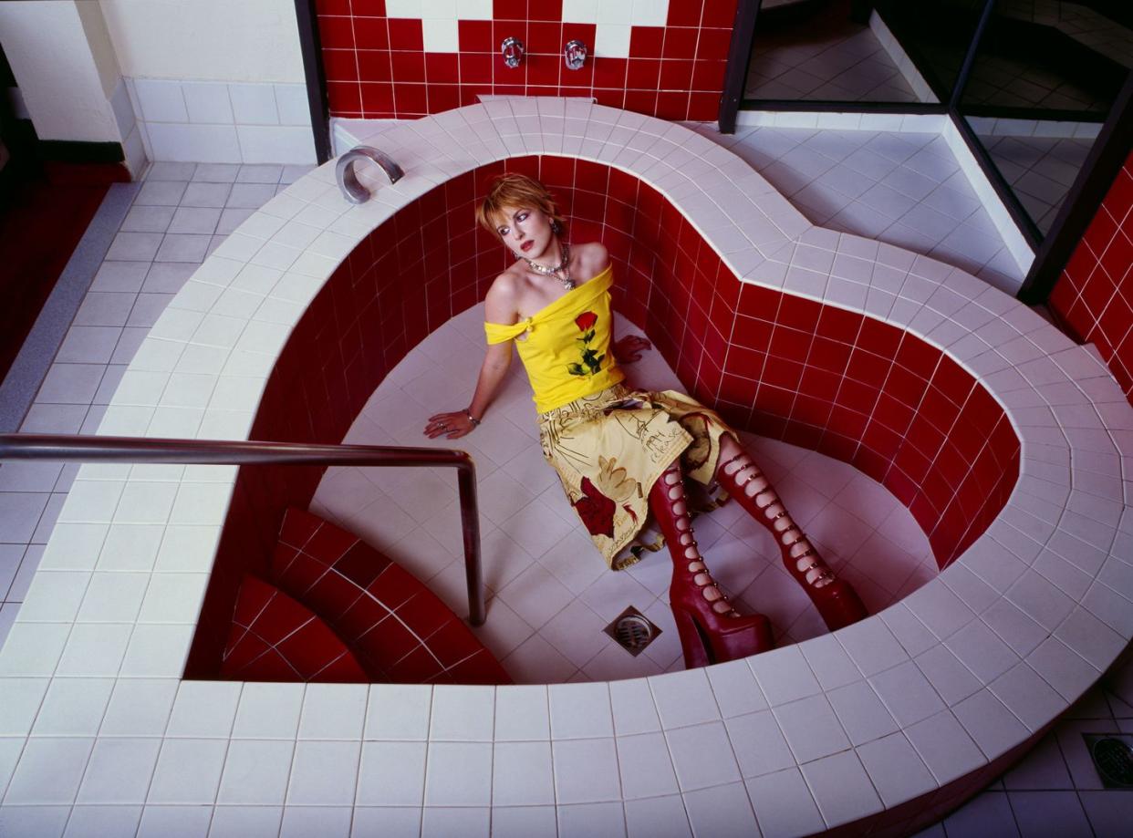 a person sitting on a red and white tiled floor